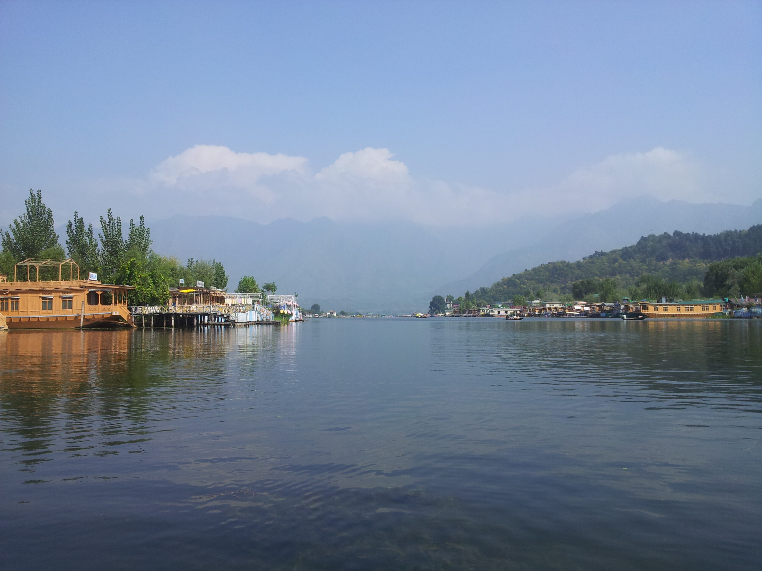 Houseboats and Shikaras on Dal Lake with mountain backdrop in Kashmir