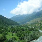 Lush green valley in Kashmir with mountains and village homes