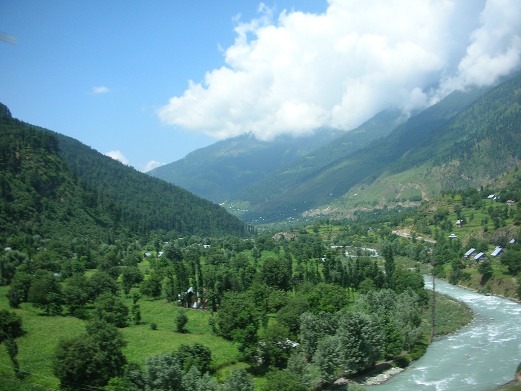 Lush green valley in Kashmir with mountains and village homes