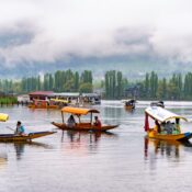 Colorful shikaras and houseboat floating on Dal Lake with mountains in Srinagar, Kashmir